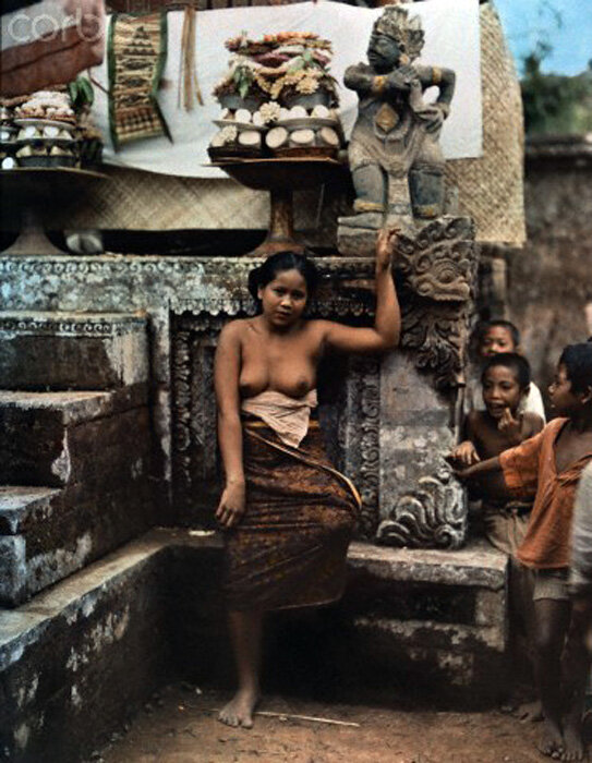 1937 Bali A woman leans against a stone platform where offerings are made by Owen Williams.jpg