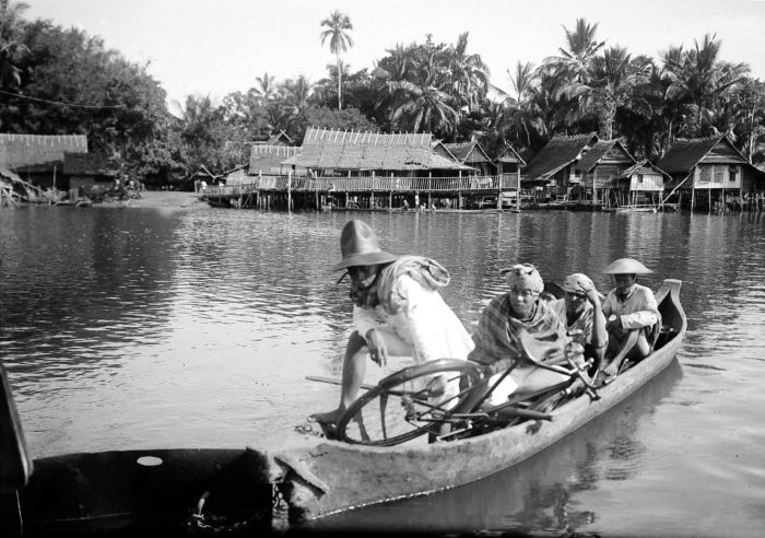 COLLECTIE_TROPENMUSEUM_Bewoners_varen_in_een_boot_over_de_rivi.jpg